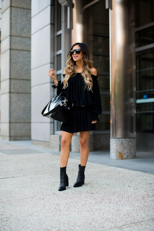 fashion blogger mia mia mine wearing a black peasant dress by norma kamali and a givenchy antigona bag