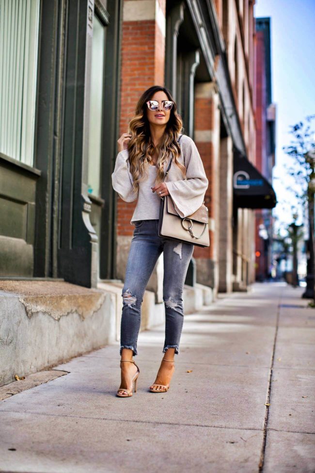 fashion blogger mia mia mine in a white sweater and grey ripped jeans from express