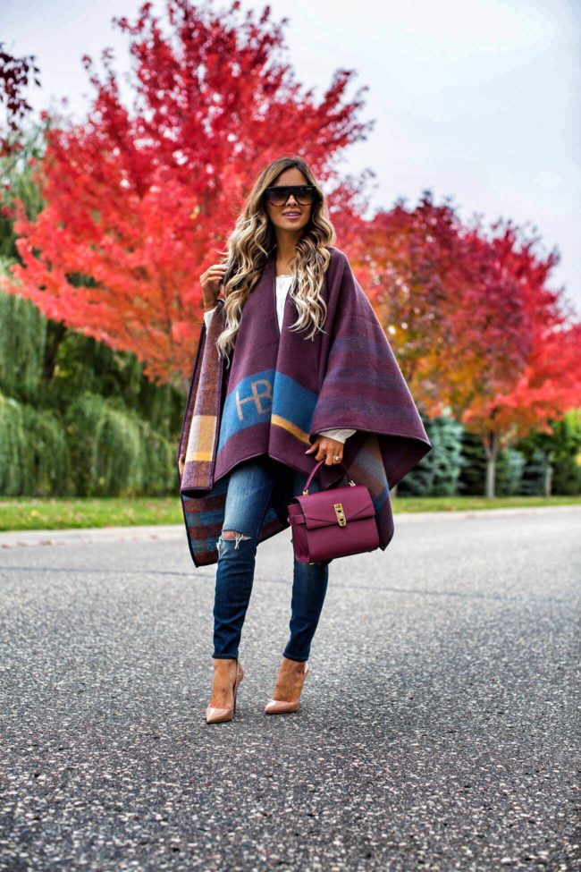 mia mia mine wearing a burgundy fall cape from henri bendel