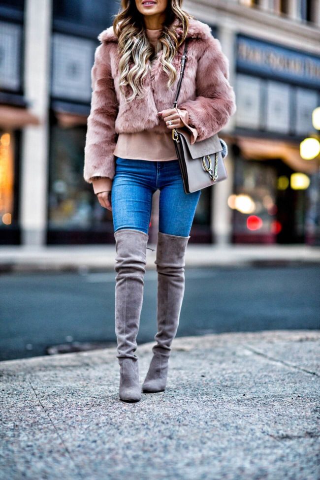 fashion blogger mia mia mine wearing a blush faux fur jacket and stuart weitzman over-the-knee boots