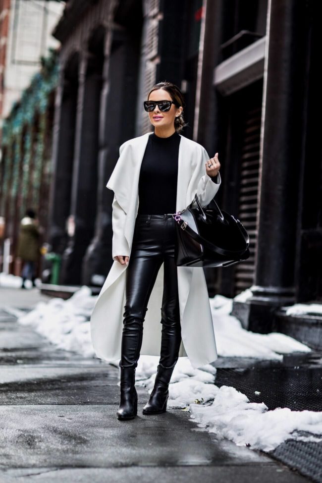 fashion blogger mia mia mine wearing a white trench coat and black leather pants at new york fashion week in february 2017