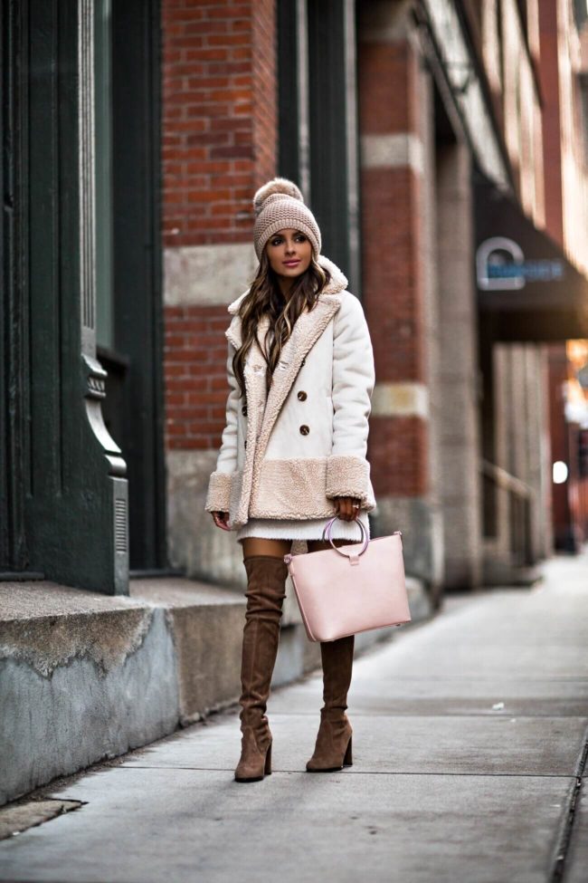 Mia Mia Mine wearing a pom beanie and faux shearling jacket