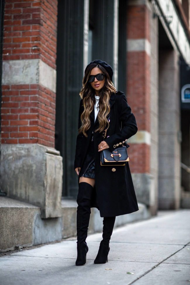 mia mia mine wearing a black double breasted coat from macy's and over the knee boots