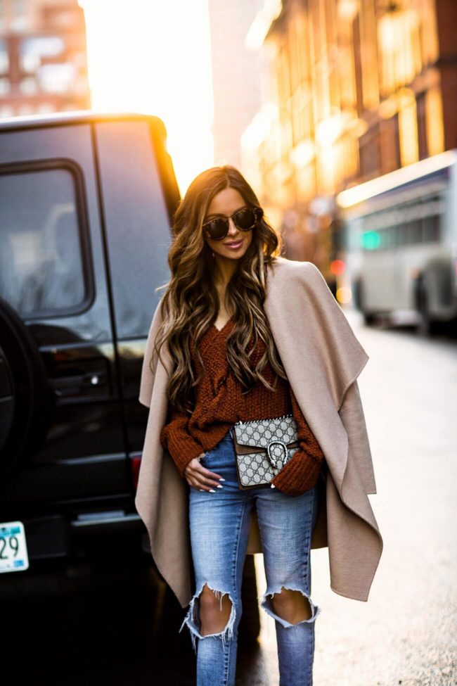 mia mia mine carrying a gucci bag and a camel coat
