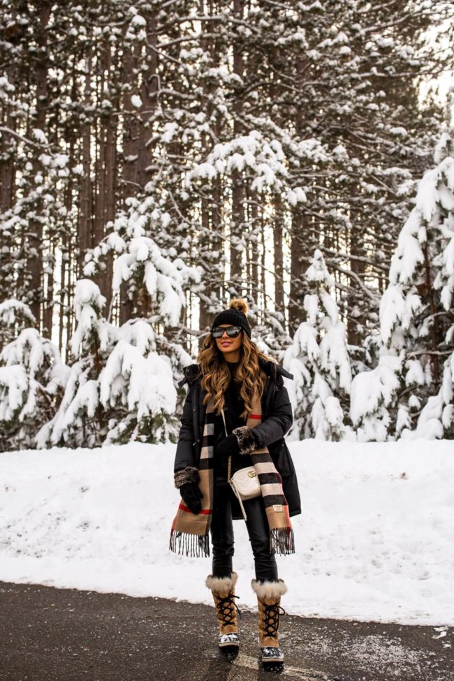 fashion blogger mia mia mine wearing a black parka and burberry scarf