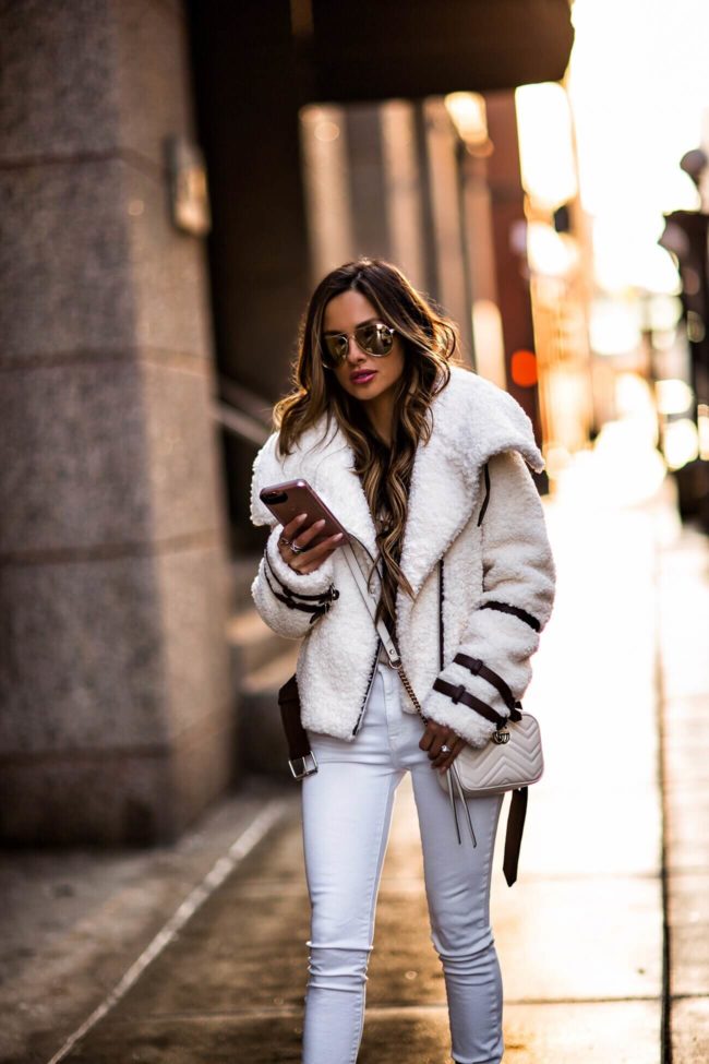 fashion blogger mia mia mine wearing a white sherpa jacket from revolve and white dl1961 denim