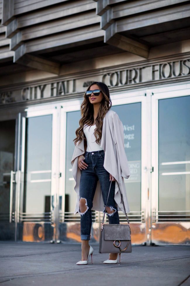 fashion blogger mia mia mine wearing a pink trench coat and gray levi's denim