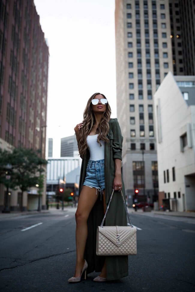 fashion blogger mia mia mine wearing levi's denim shorts and an olive trench coat from revolve