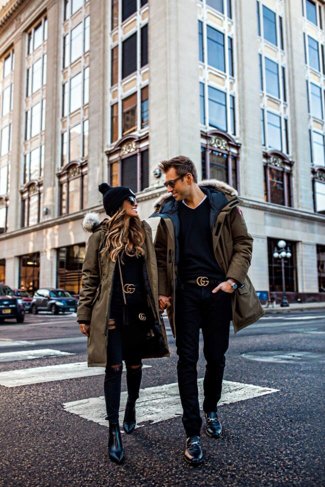 fashion blogger mia mia mine wearing a canada goose jacket and a gucci belt wtih husband phil