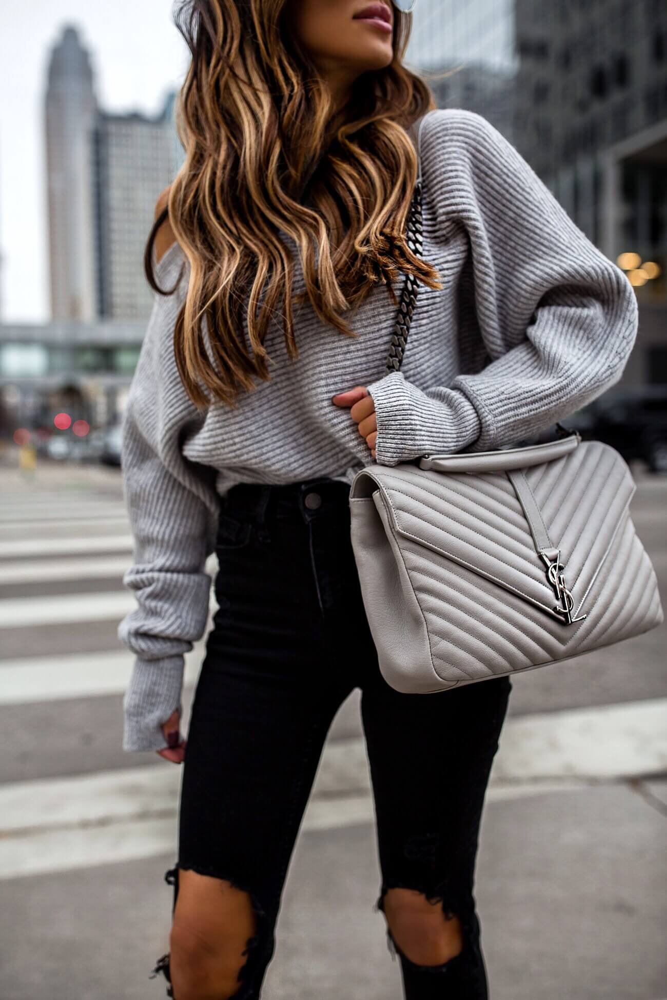 fashion blogger mia mia mine wearing a gray saint laurent college bag and a gray off-the-shoulder sweater from intermix