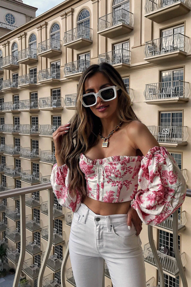 fashion blogger mia mia mine wearing a pink top from revolve in naples florida at the ritz-carlton