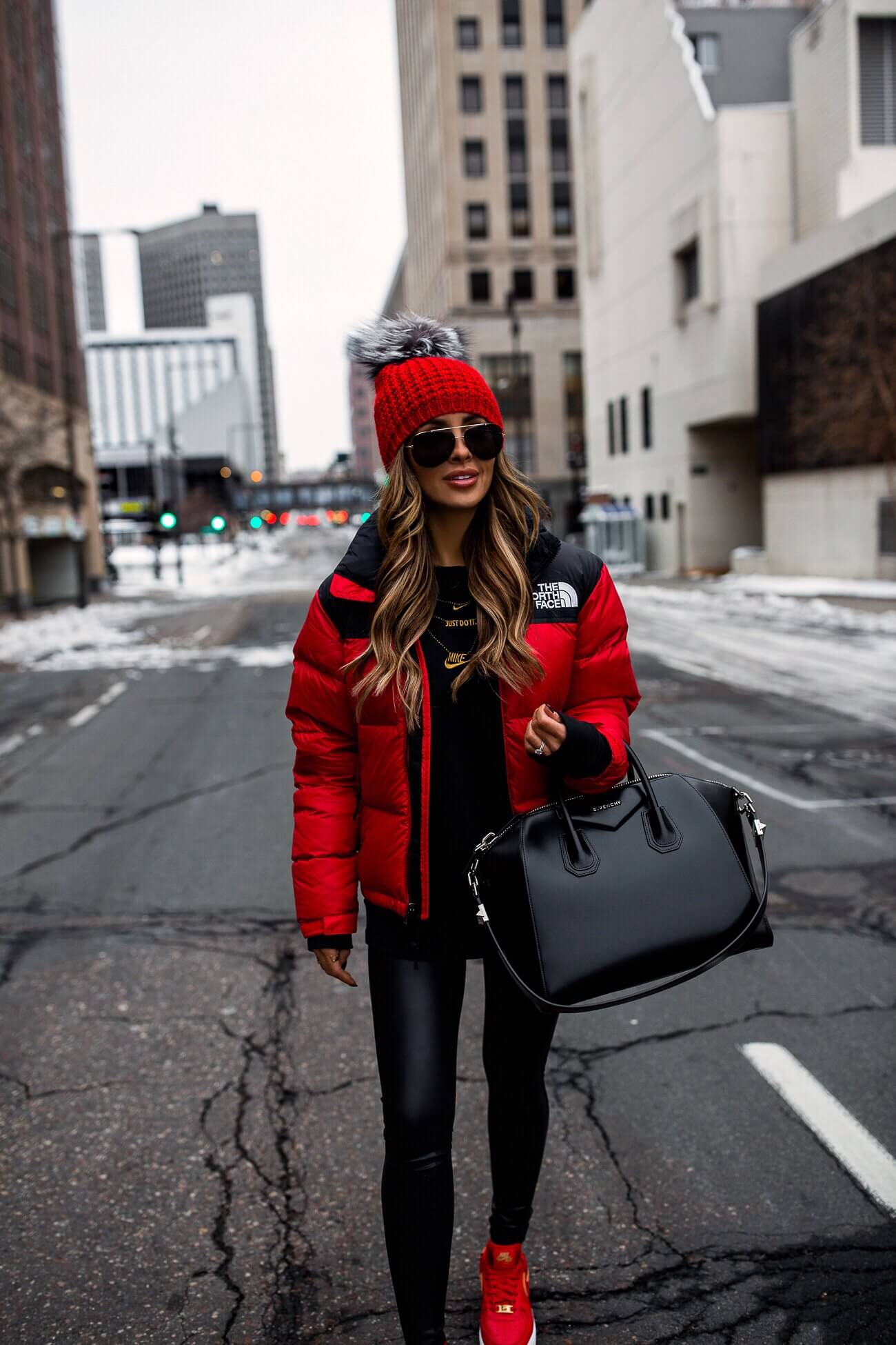 fashion blogger mia mia mine wearing a red north face jacket with a givenchy antigona bag