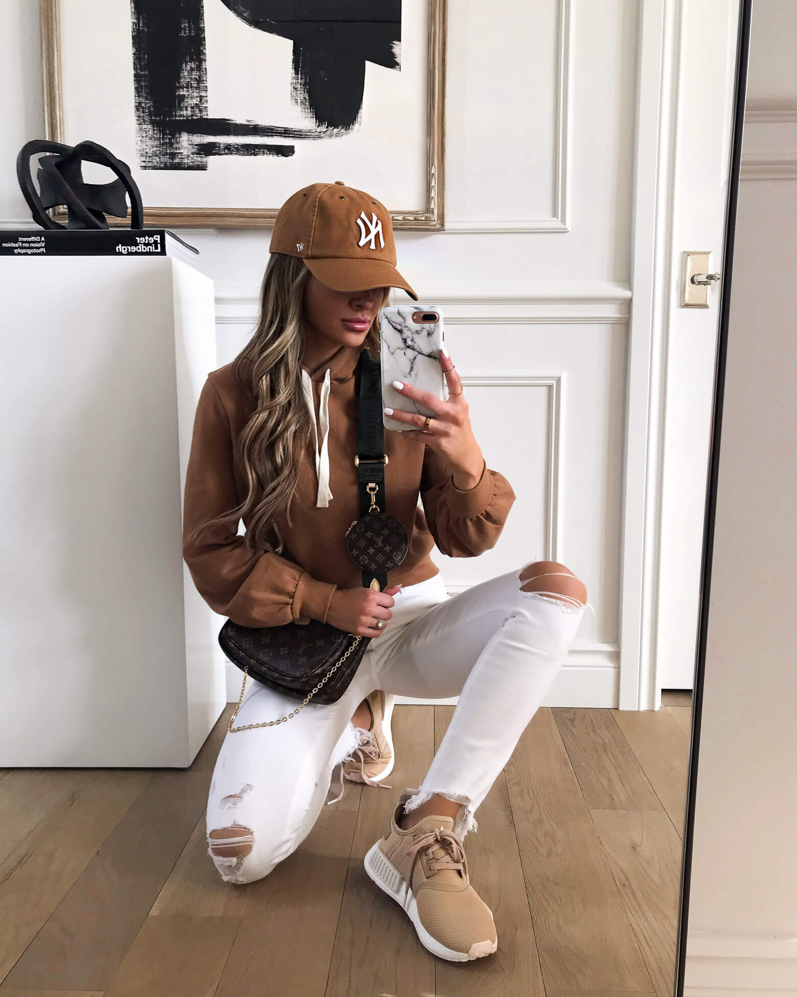 fashion blogger mia mia mine wearing white denim and adidas sneakers at home