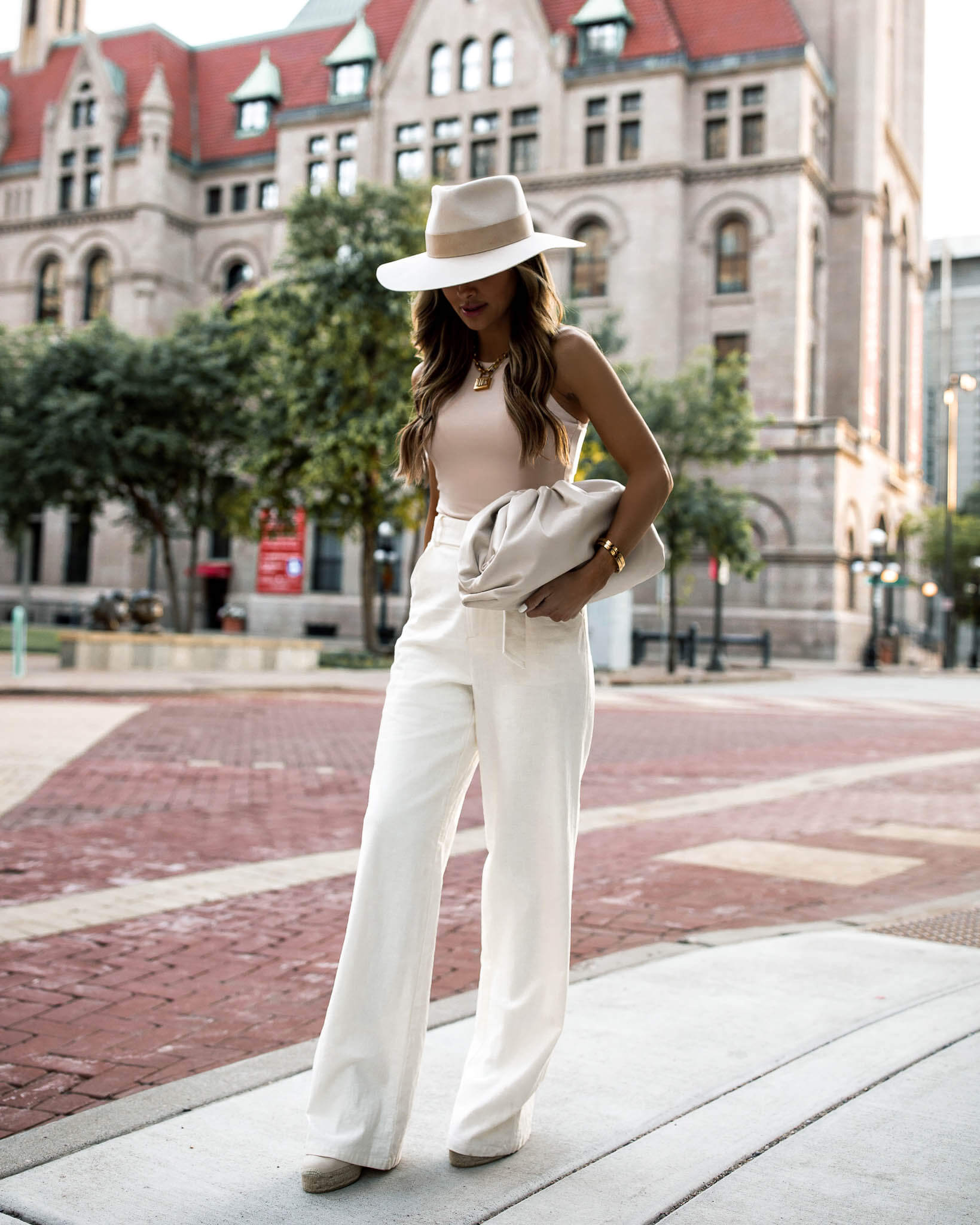 fashion blogger mia mia mine wearing white linen pants and a janessa leone hat for summer 2020