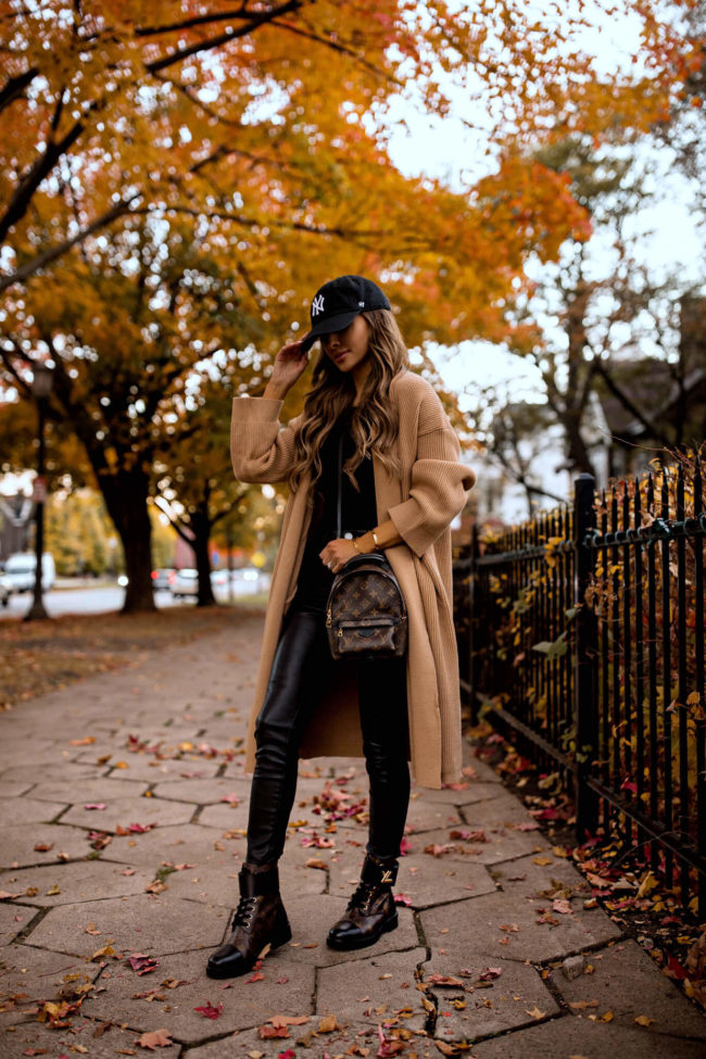 fashion blogger mia mia mine wearing a camel coat and louis vuitton wonderland flat rangers