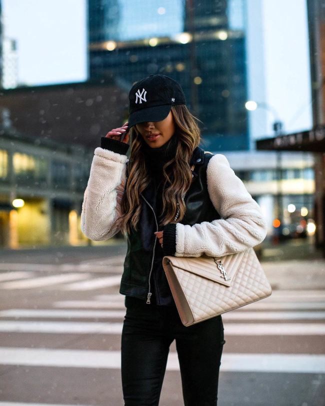 fashion blogger mia mia mine wearing a shearling moto jacket from express and ny yankees baseball cap