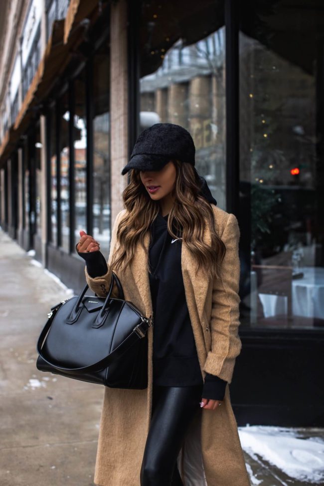 fashion blogger wearing a nike sweatshirt and a faux fur baseball hat from nordstrom