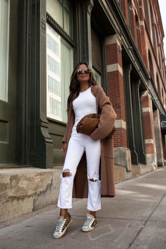 fashion blogger mia mia mine wearing a camel coat and a bottega veneta the pouch bag