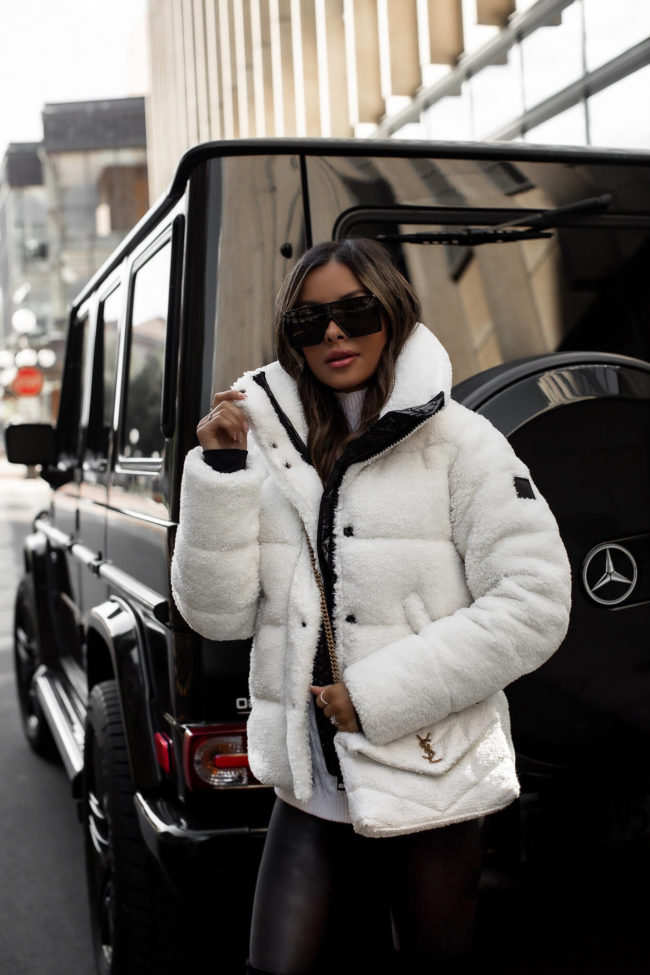 fashion blogger wearing a white sherpa puffer jacket and spanx faux leather leggings from saks fifth avenue