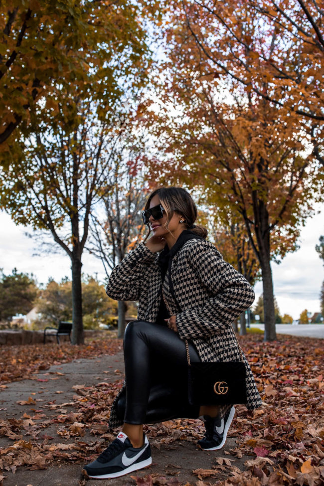 fashion blogger wearing nike sneakers and a houndstooth blazer