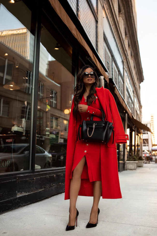 fashion blogger wearing a red knit dress and red coat from karen millen