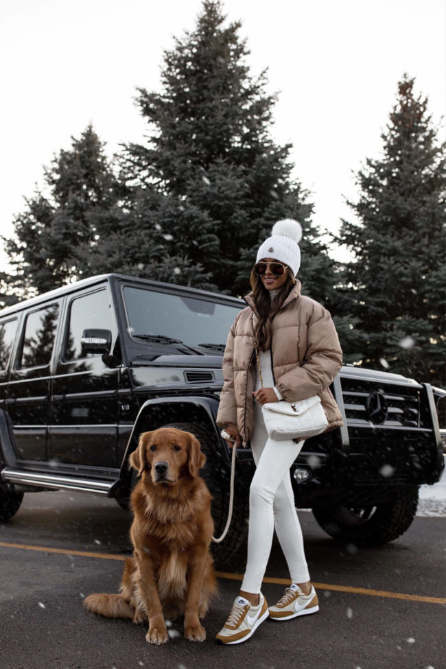 fashion blogger mia mia mine wearing a white ski outfit and nike daybreak sneakers