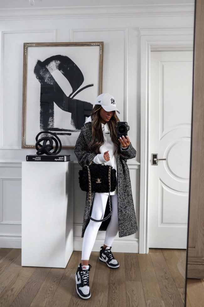 fashion blogger wearing white alo yoga leggings and nike dunk high sneakers