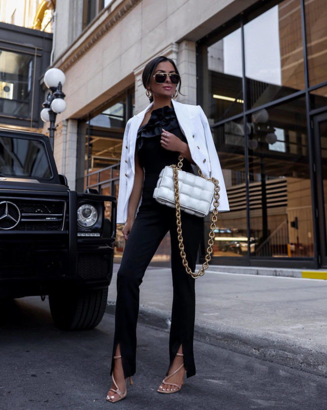 fashion blogger wearing black slit pants and a statement top from express