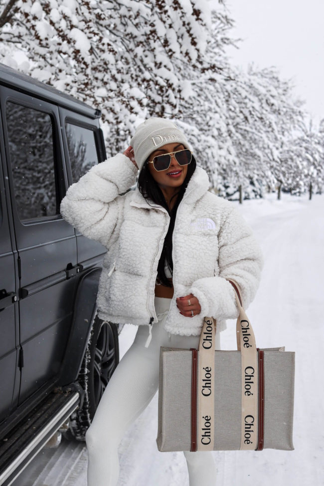 fashion blogger mia mia mine wearing a sherpa north face jacket and chloe woody tote