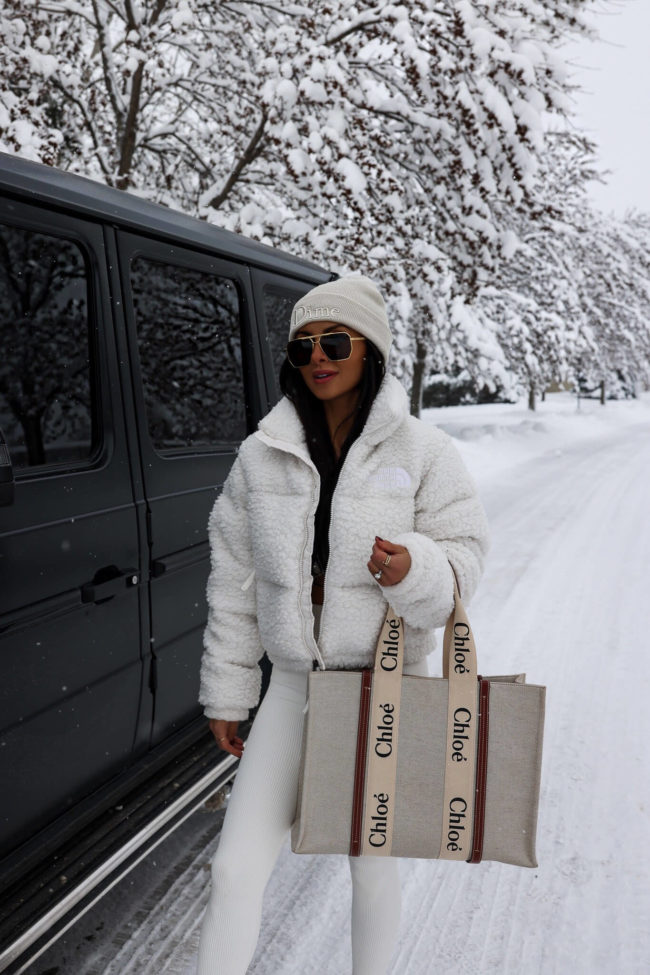 fashion blogger mia mia mine wearing a white sherpa north face puffer jacket