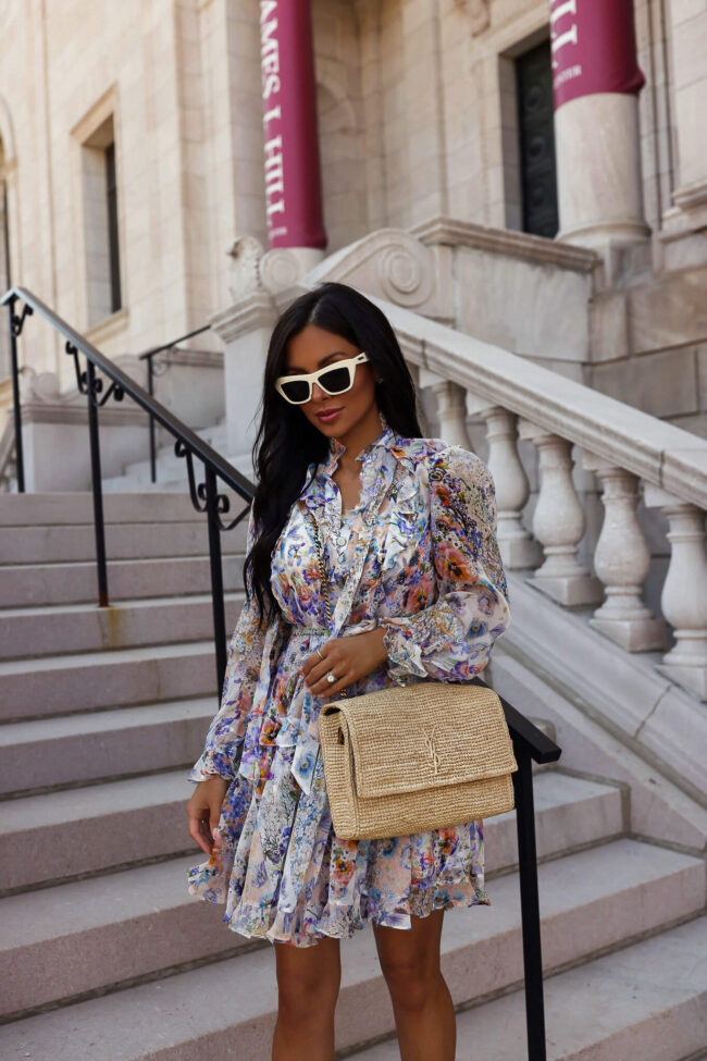 fashion blogger mia mia mine wearing a floral dress and raffia bag from saks