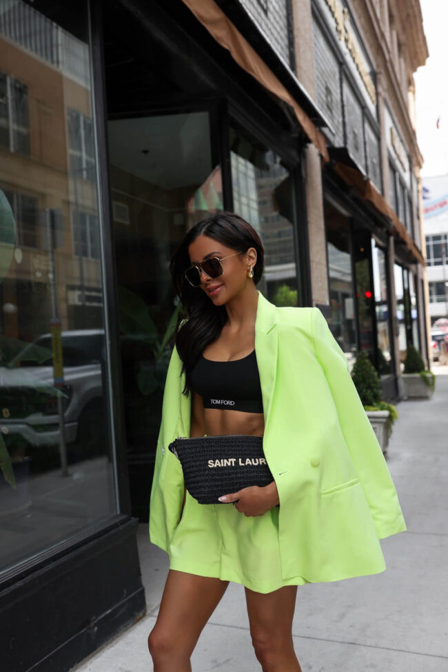 woman wearing a black tom ford bralette under a lime green blazer 