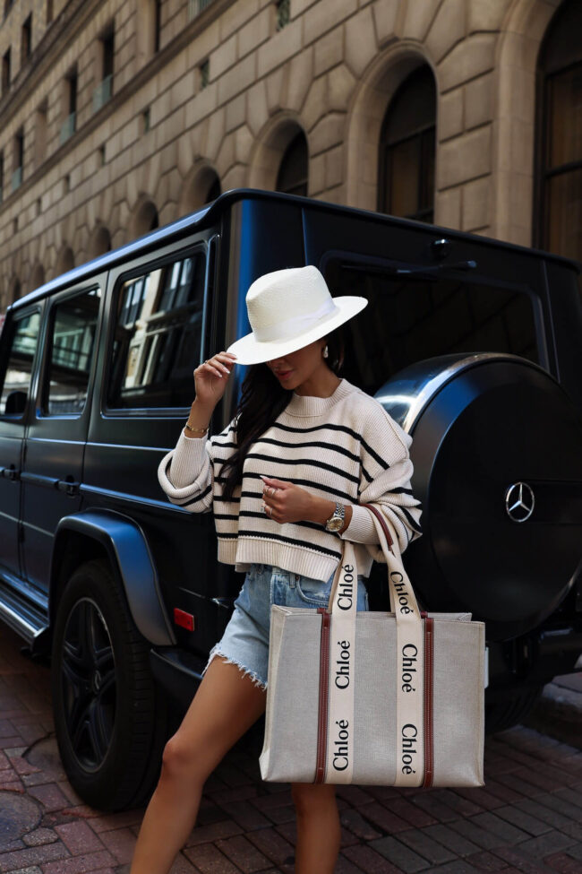 fashion blogger wearing a striped sweater and cut-off denim shorts for summer