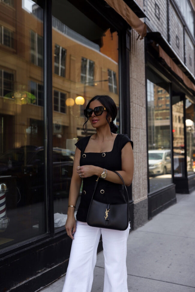 fashion blogger wearing a black linen vest and white jeans from saks